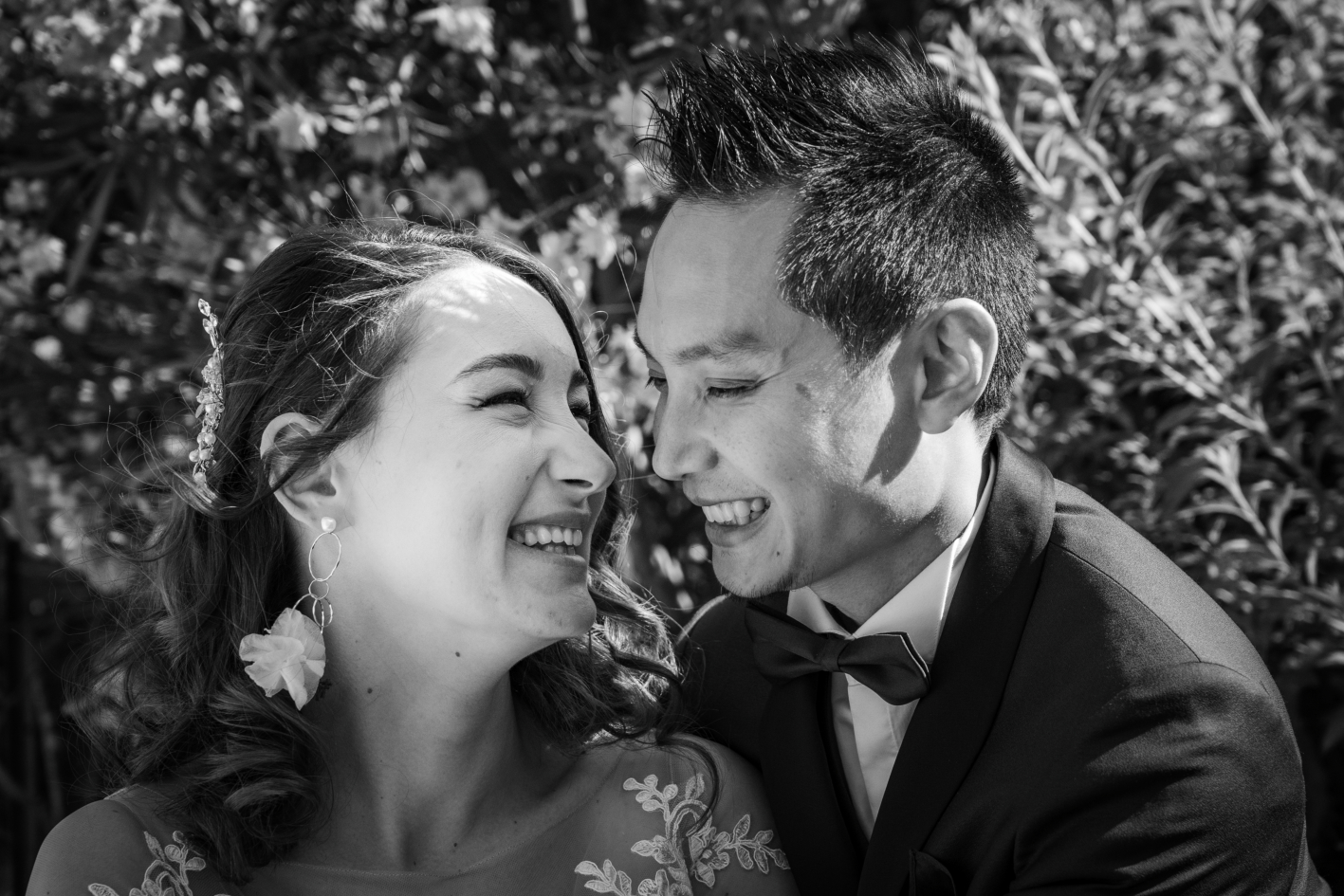 Photo en noir et blanc de mariés qui se regardent en souriant.
