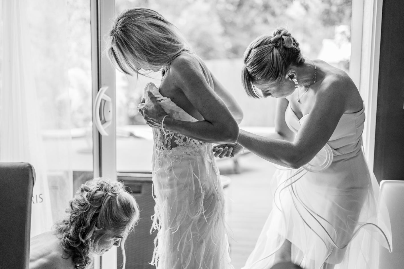 La famille de la mariée l'aide à préparer sa robe.